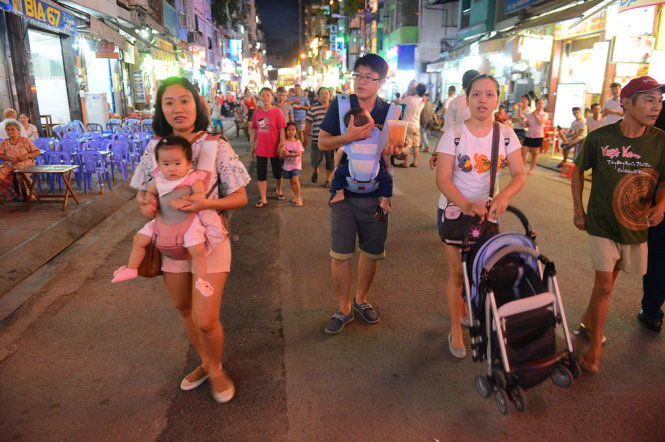 Visitors leisurely walk along Bui Vien.