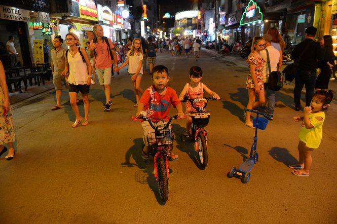Children ride bicycle on Bui Vien.