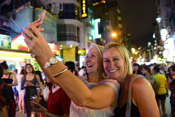 Two foreign tourists take a selfie at Bui Vien Walking Street.