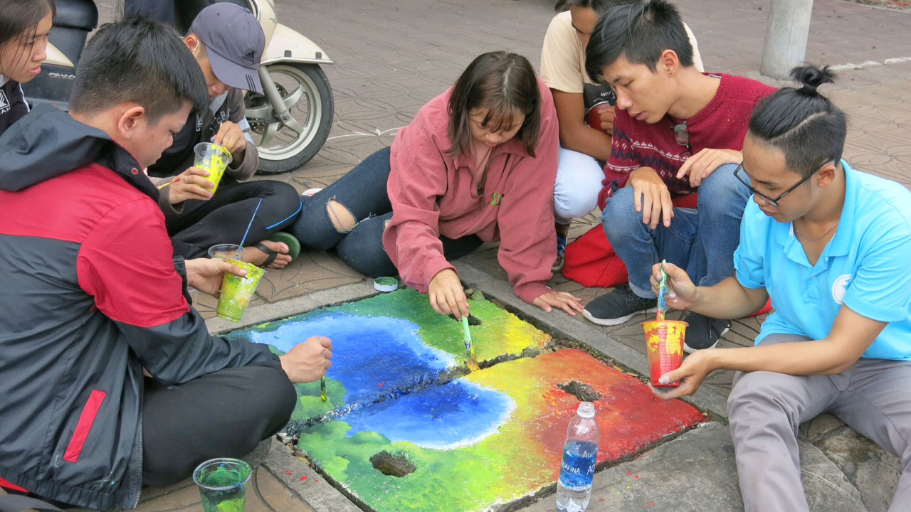 Vietnamese students draw on manhole lids to protect environment