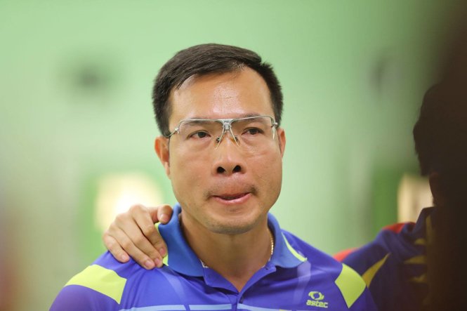 Vietnam's shooter Hoang Xuan Vinh looks deject after his failure.