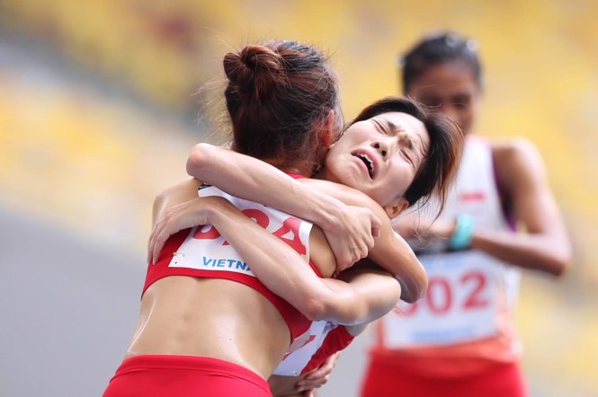 Vietnam sprinters Nguyen Thi Oanh and Pham Thi Hue celebrate after winning their women's 5,000m gold and silver medals.