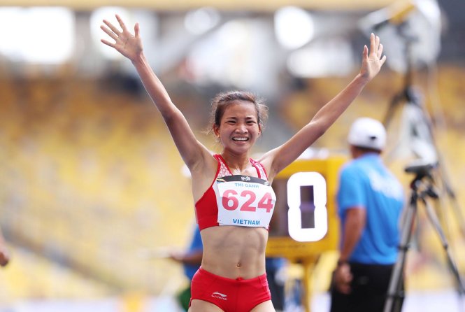 Vietnam's sprinter Nguyen Thi Oanh celebrates after winning the women 5,000m gold medal.