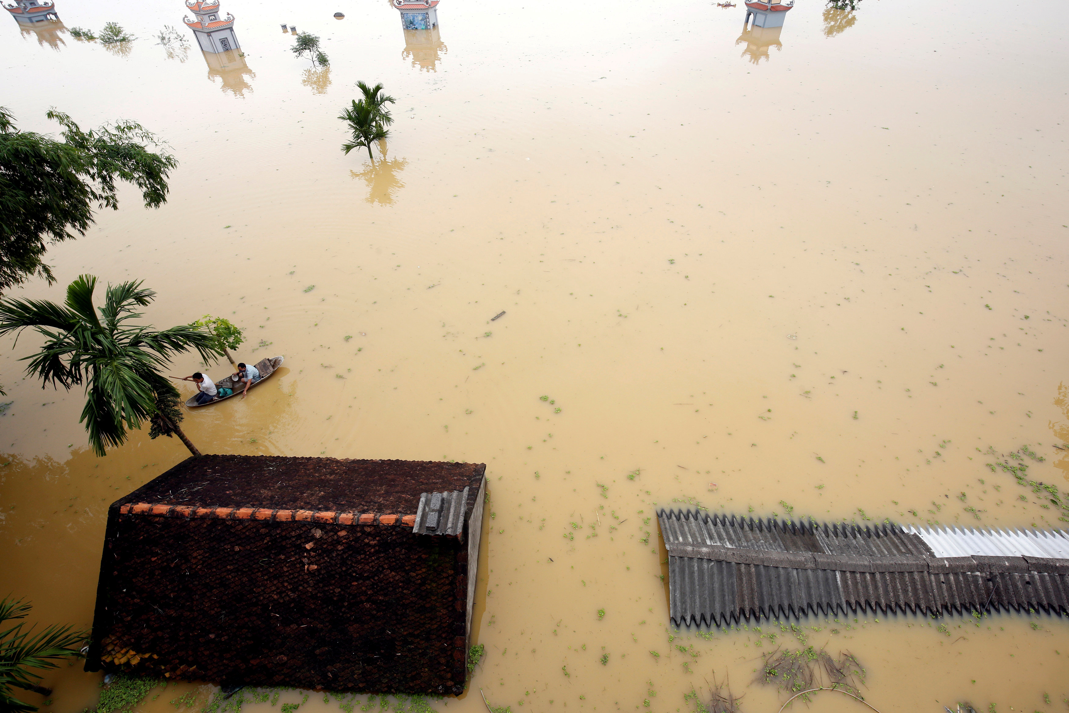 Farmers paddle in a boat at a flooded village after a tropical depression in Hanoi, Vietnam October 13, 2017. Photo: Reuters