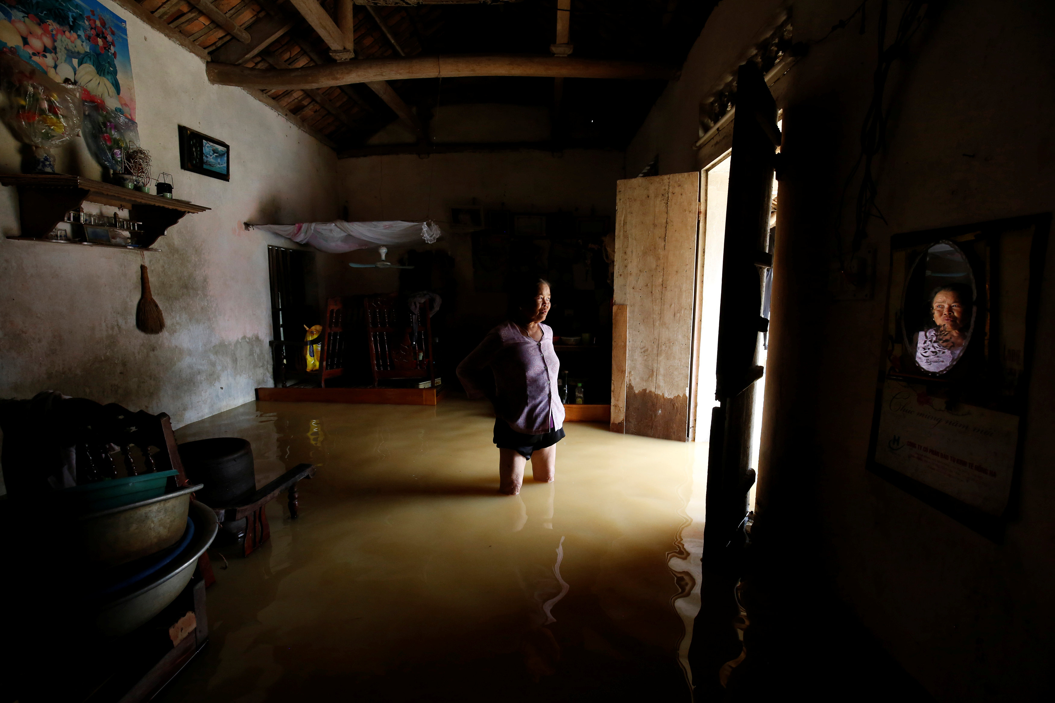 A farmer stands in her flooded house after a tropical depression in Hanoi, Vietnam October 13, 2017. Photo: Reuters