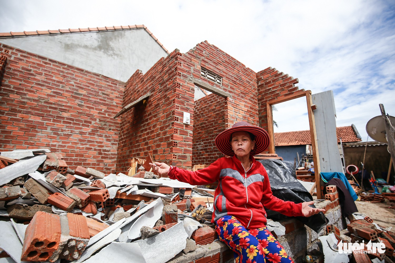 Phan Thi Lac, 63, sits by the debris of her home in Van Phuoc Commune.