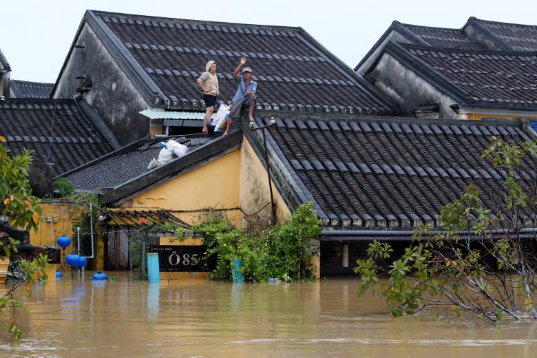 People stand on the roof of their house along submerged street in the UNESCO heritage ancient town of Hoi An after Typhoon Damrey hits Vietnam. Photo: Reuters