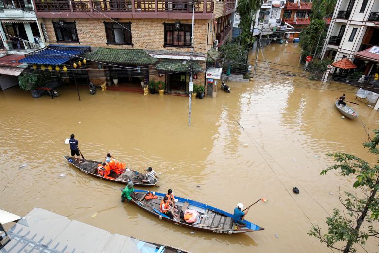 People travel on a boat along submerged by Typhoon Damrey houses in the UNESCO heritage ancient town of Hoi An, Vietnam. Photo: Reuters