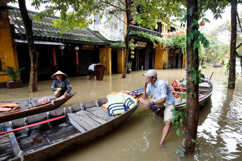 People sit on a boat at a flooded by Typhoon Damrey street in the UNESCO heritage ancient town of Hoi An, Vietnam. Photo: Reuters