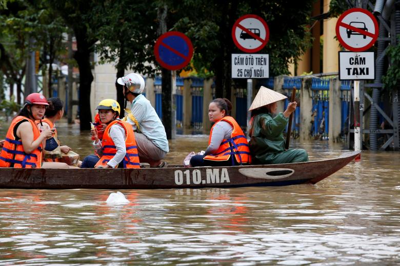 People ride a boat along a flooded by Typhoon Damrey street in the UNESCO heritage ancient town of Hoi An, Vietnam. Photo: Reuters