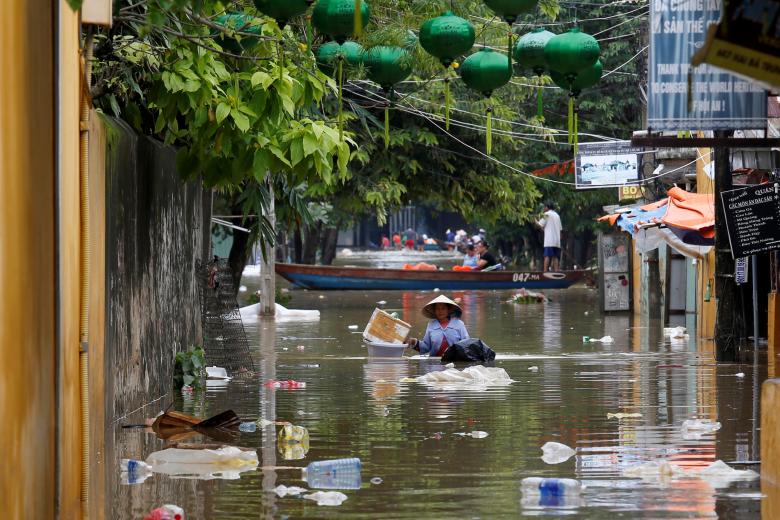 A woman wades along submerged by Typhoon Damrey houses in the UNESCO heritage ancient town of Hoi An, Vietnam. Photo: Reuters