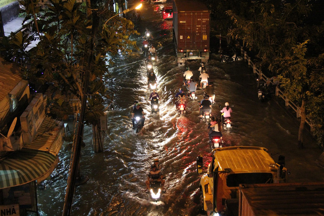 Vehicles travel through floodwater on Tran Xuan Soan Street in District 7, Ho Chi Minh City December 5, 2017. Photo: Tuoi Tre