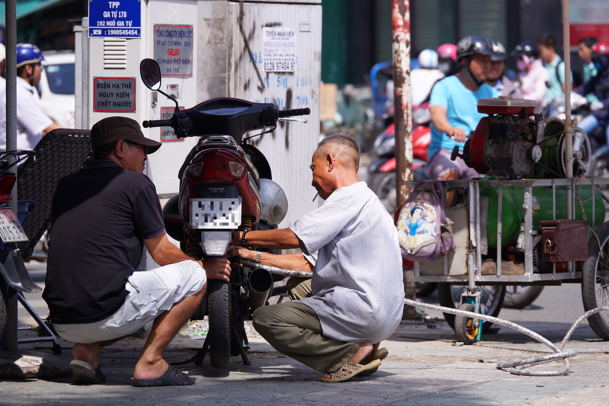 Working as repairmen along busy streets in the motorbike kingdom of Saigon