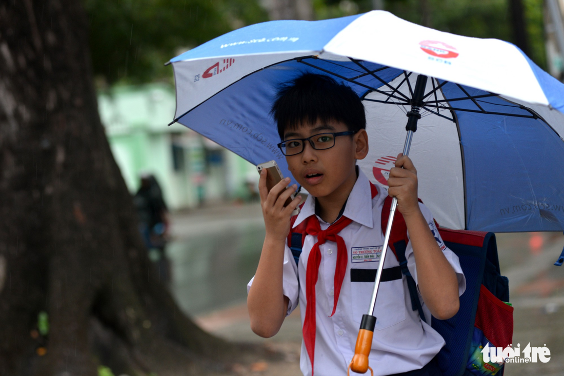 A sixth-grader calls his parents to pick him up early in Ho Chi Minh City on December 25, 2017. Photo: Tuoi Tre