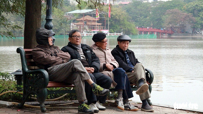Senior citizens sit by the Sword Lake.