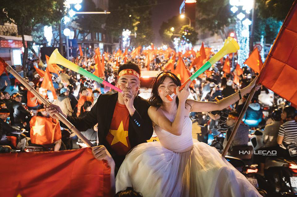 ​Hanoi couple shoots pre-wedding album amid crowds reveling in Vietnam’s AFC U23 victory