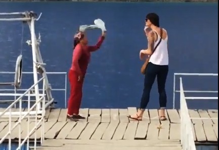 Senior Vietnamese citizen shoos tourist from floating dock
