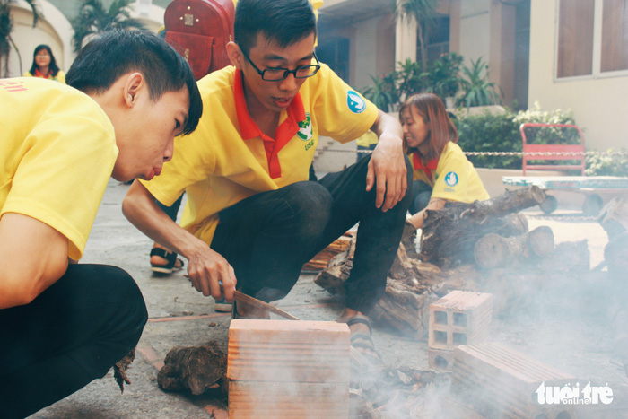 A number of young volunteers were puzzled with the wooden kindling. “This is the first time we’ve had to kindle a fire. It felt like “the olden days” of our ancestors,” Nguyen Gia Bao (19, volunteer) said. Photo: Tuoi Tre