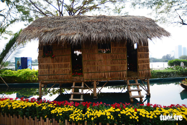 Model of a thatched house is built on a pond in Phu My Hung. Photo: Tuoi Tre