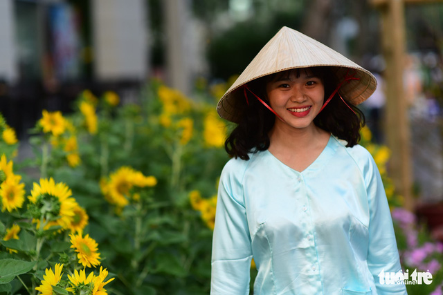 A woman wears a Vietnamese ba ba blouse and a conical hat in Phu My Hung. Photo: Tuoi Tre