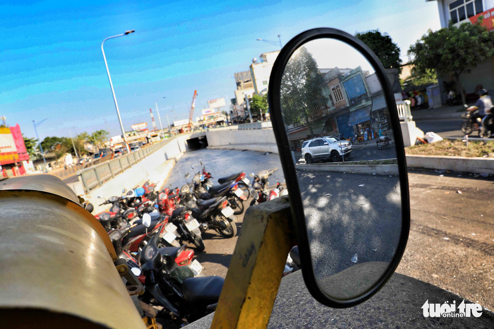 The reflection of a car is seen through a mirror on a roller working at the An Suong underpass in Ho Chi Minh City. Photo: Tuoi Tre