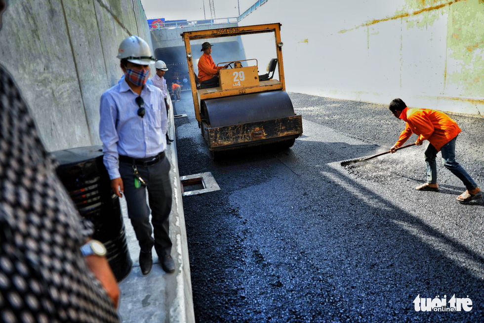 Workers install asphalt on the first branch of the An Suong underpass in Ho Chi Minh City. Photo: Tuoi Tre