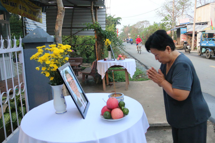 A woman bows to the photo of PM Phan Van Khai displayed on the altar.