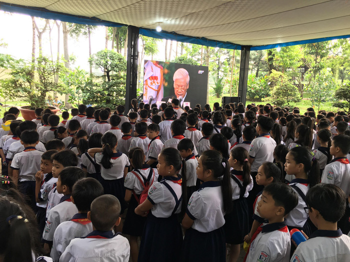 Students of the Tan Thong Elementary School gather at the house of PM Khai to witness the celebration of life.