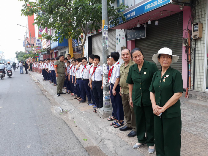 Local residents stand along the street near the Cong Hoa-Hoang Hoa Tham flyover.