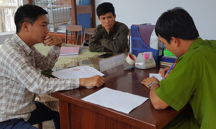 Duong Du Tuan (L) and Chu Ngoai Oai report the incident to police in Nhon Binh Ward in the south-central province of Binh Dinh. Photo: Tuoi Tre
