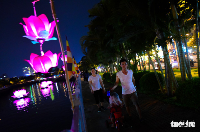 Local people enjoy a walk along the embankment of Nhieu Loc – Thi Nghe Canal in the beautiful light of brightly-colored lanterns. Photo: Tuoi Tre