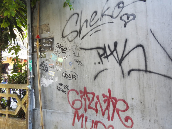 The wall at the corner of Tran Phu Street, next to the emblematic Cau (Bridge) Pagoda of Hoi An is full of writings. Photo: Tuoi Tre