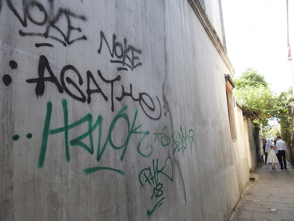 This wall along the must-visit narrow alley where a famous well is situated in Hoi An City is covered with spray paint. Photo: Tuoi Tre