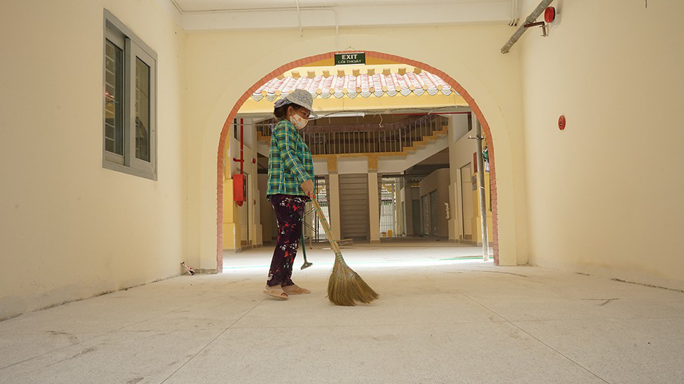 A woman sweeps dust off the newly re-tiled ground floor of the Binh Tay Market in District 6, Ho Chi Minh City. Photo: Tuoi Tre