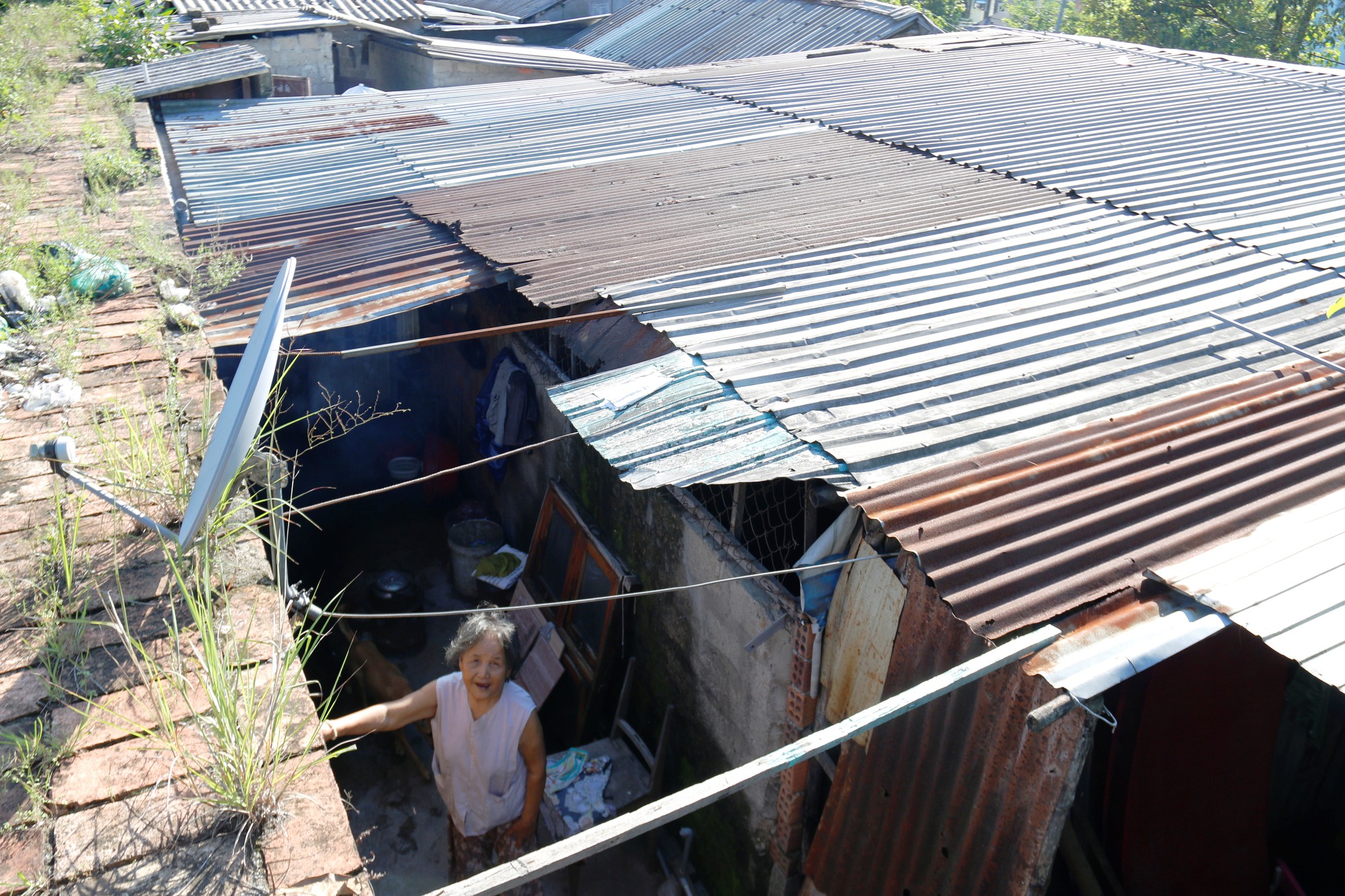 A house has its roof built shoddily with just a few metal sheets. Photo: Tuoi Tre
