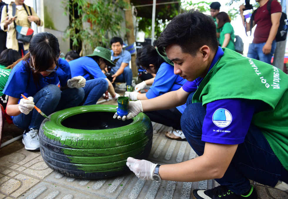 Volunteers decorate old tires to build the playground. Photo: Tuoi Tre