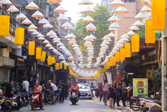Hundreds of Vietnam’s iconic ‘non la’ hats float above street in Hanoi