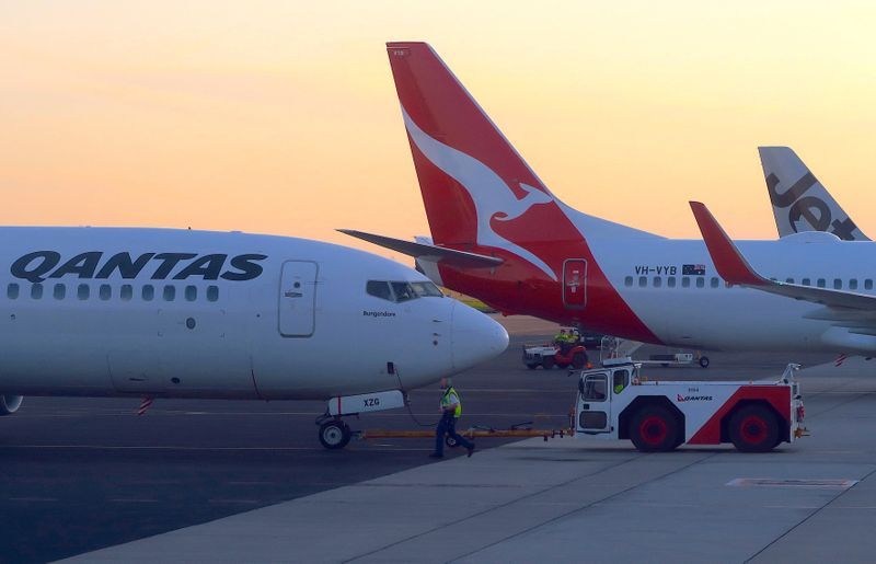 Passengers evacuate Qantas plane via emergency slides at Sydney airport