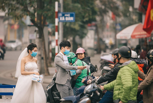 Couple gives away face masks on Hanoi streets in viral pre-wedding photos