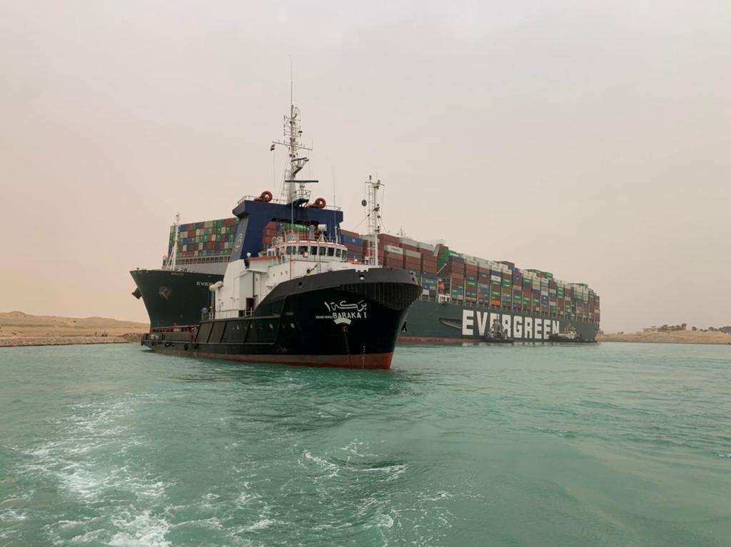 Tug boats work to free giant container ship stuck in Suez Canal