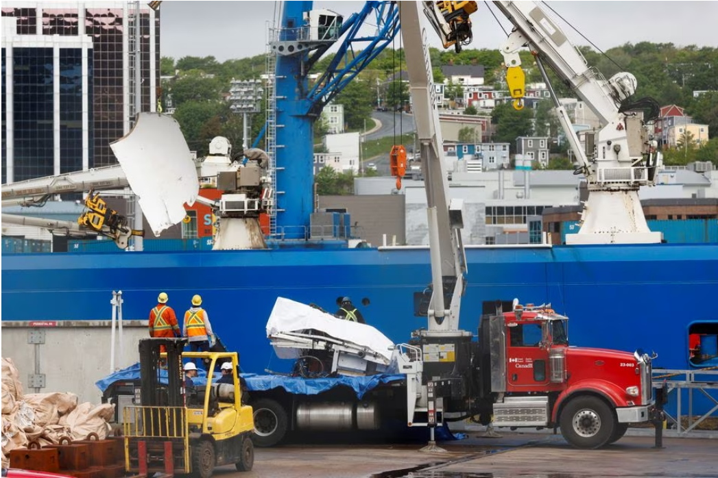 Presumed human remains and shattered Titanic submersible returned to shore