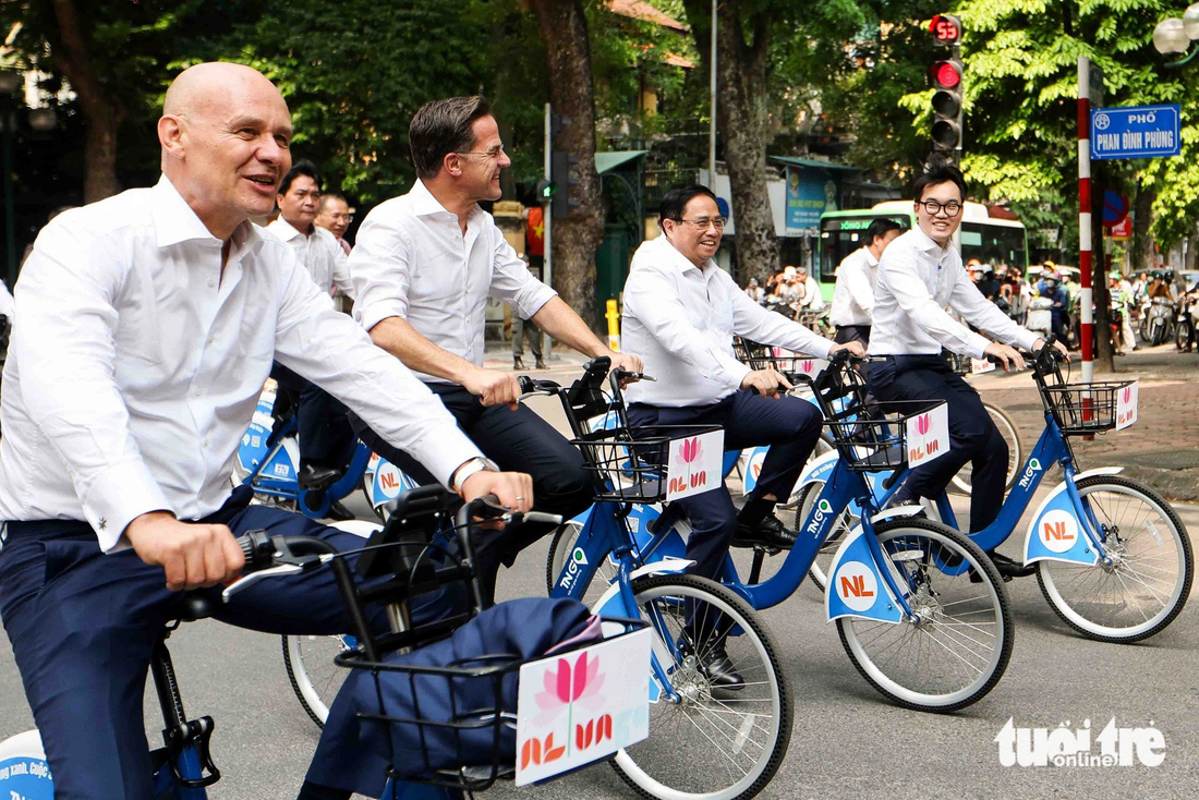 Vietnamese Prime Minister Pham Minh Chinh (R, 2nd) and Dutch Prime Minister Mark Rutte (L, 2nd) cycle on Phan Dinh Phung Street, one of the most beautiful streets in Hanoi. Photo: Nguyen Khanh / Tuoi Tre