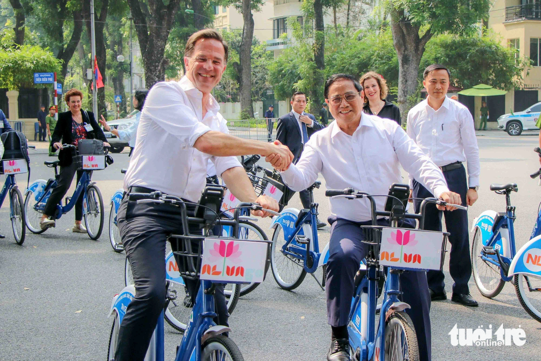 The two officials shake hands at the end of the cycling journey. The Dutch premier later cycled to a famed coffee shop on Dien Bien Phu Street, where he met with some Vietnamese female entrepreneurs. Photo: Duy Linh / Tuoi Tre