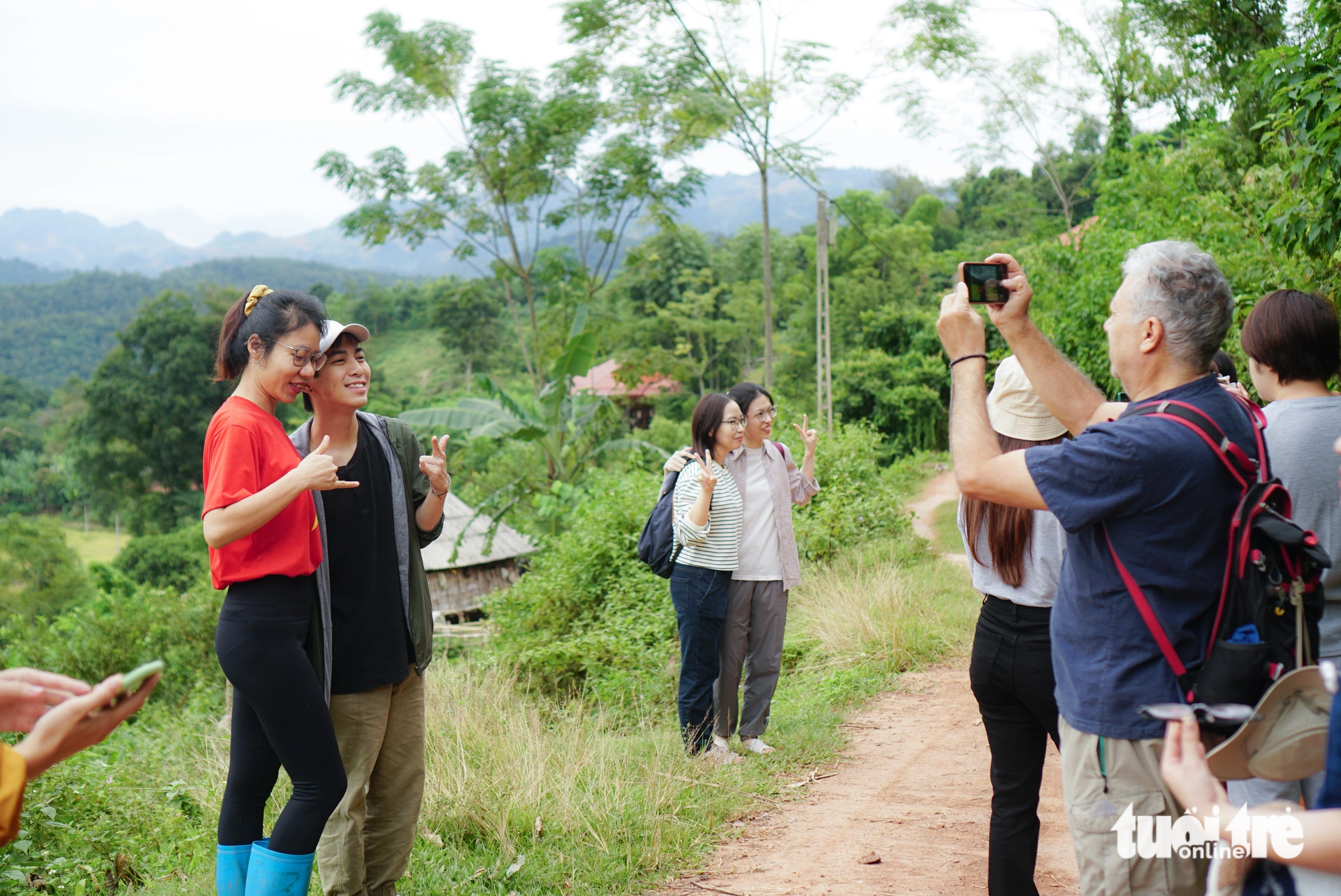 Tourists take photos on the way to the rice fields. Photo: Nguyen Hien / Tuoi Tre