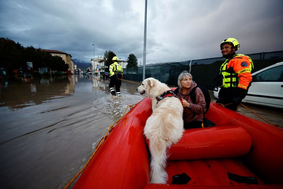 Carla and her dog Dante are carried on a fire brigade dinghy after being rescued in the aftermath of Storm Ciaran, in Oste, in Tuscany region, Italy, November 3, 2023. Photo: Reuters