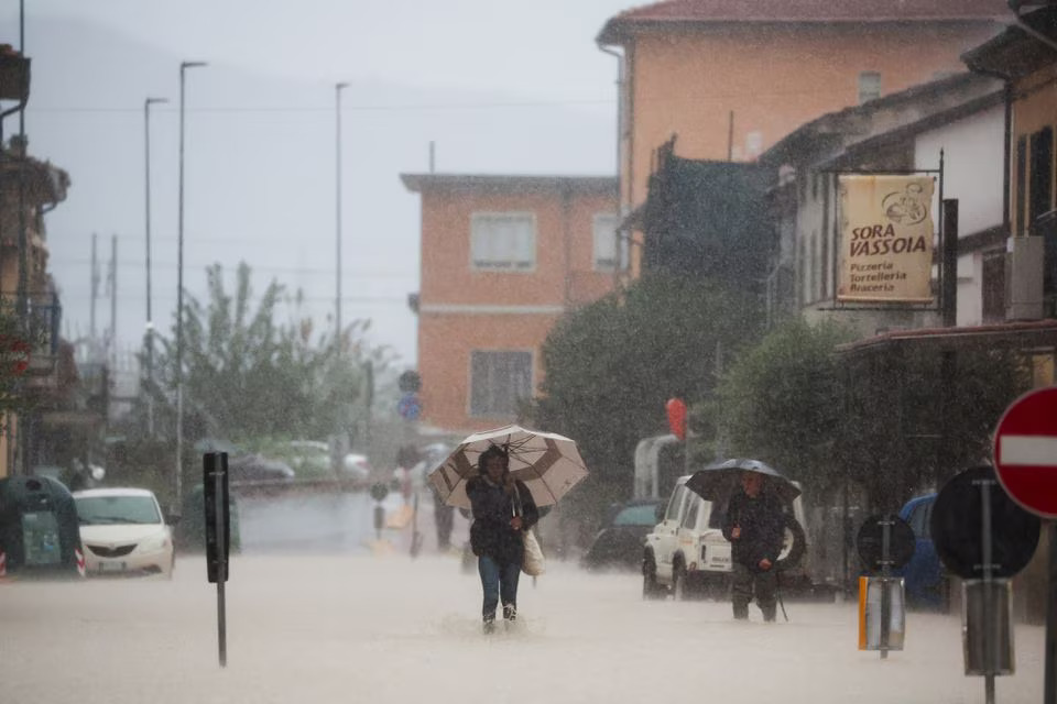 People walk in a flooded street in the aftermath of Storm Ciaran, in Oste, in Tuscany region, Italy, November 3, 2023. Photo: Reuters