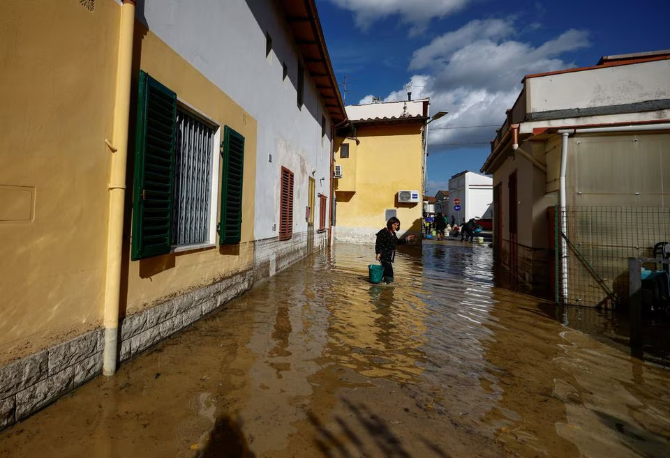 Enza Carfagno stands on a flooded street in the aftermath of Storm Ciaran, in Campi Bisenzio, in Tuscany region, Italy, November 3, 2023. Photo: Reuters