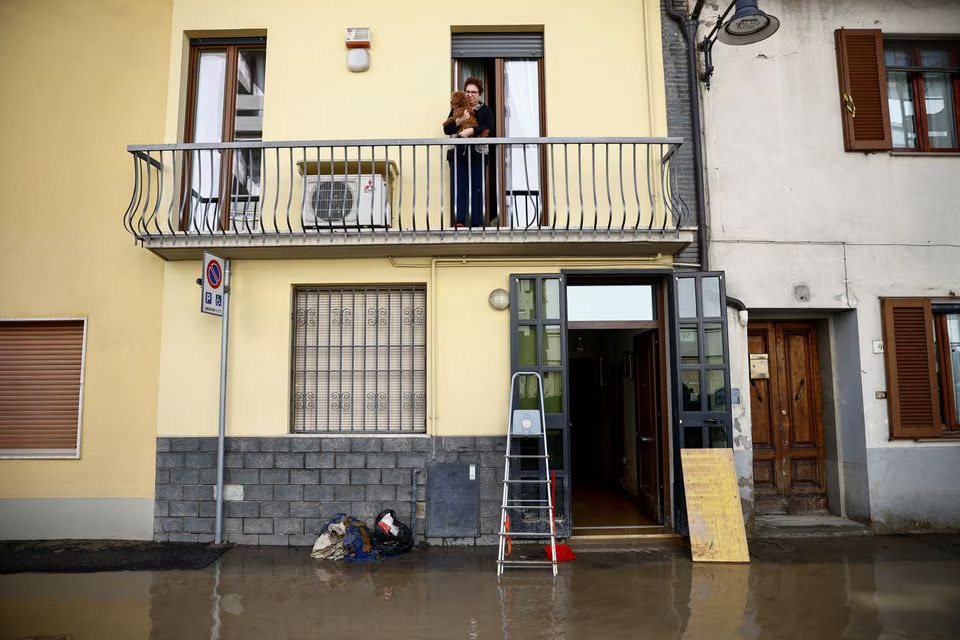 A woman stands on a balcony with her dog in the aftermath of Storm Ciaran, in Campi Bisenzio, in Tuscany region, Italy, November 3, 2023. Photo: Reuters