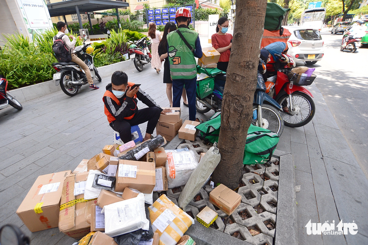 White-collar workers in District 1, Ho Chi Minh City receive products ordered online. Photo: Quang Dinh / Tuoi Tre