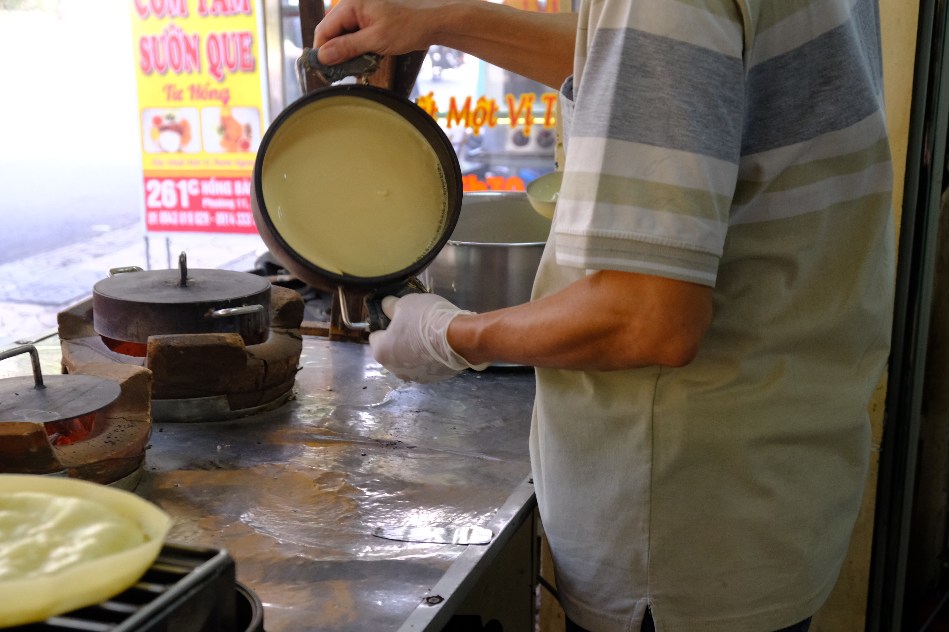A baker pours the batter onto a hot metal mold to make the crust of ‘bánh bò dừa’. Photo: Minh Chau / Tuoi Tre News